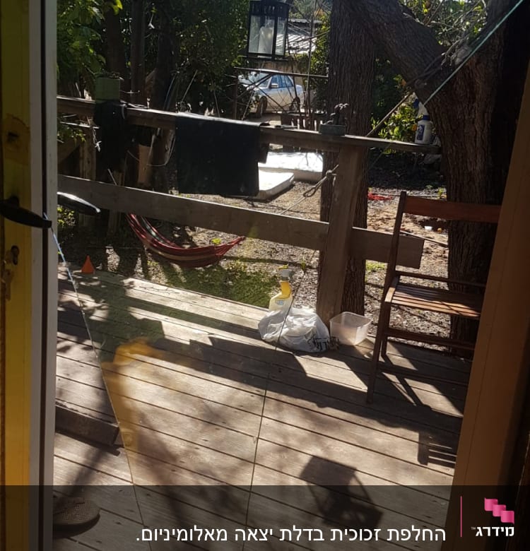 זכוכית שבורה על רצפת עץ במרפסת חיצונית